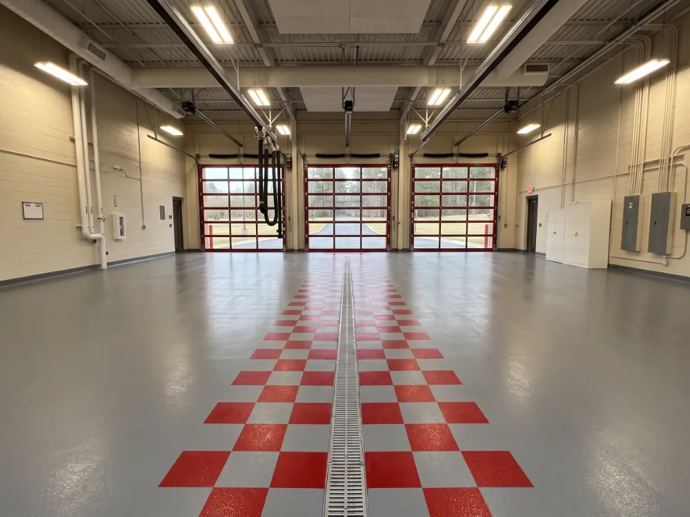 Empty apparatus bay with coved epoxy floor, trench drain and zone banding