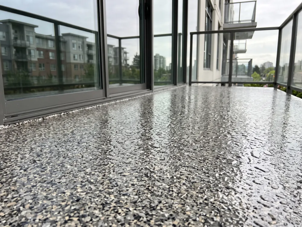 Condo balcony floor with rain water beading harmlessly on the sealed flake surface