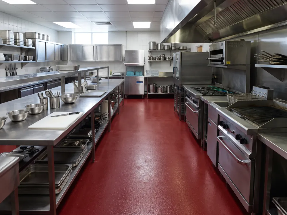 Commercial kitchen with a seamless dark red urethane cement floor and stainless cooking line