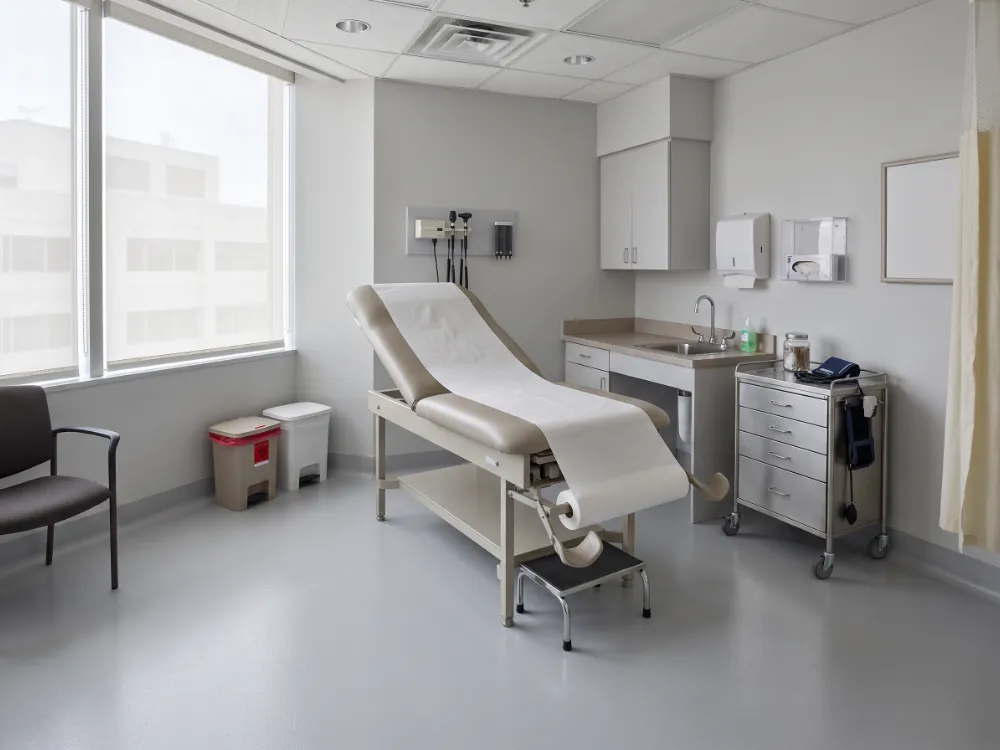 Medical exam room with a seamless pale gray epoxy floor and cove base