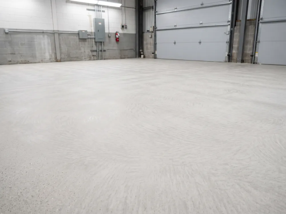 Fully ground clean uniform pale concrete garage floor ready for coating