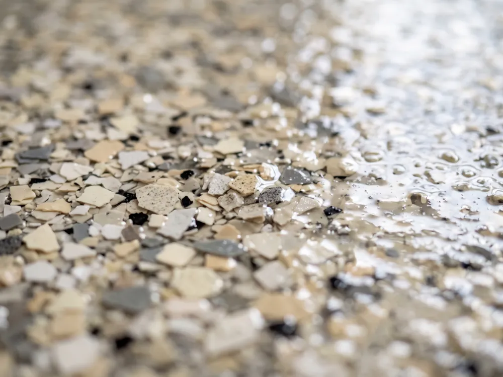 Cream and gray flake epoxy floor close-up with soft window light reflection