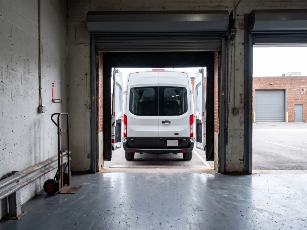 Small loading dock with a dark gray epoxy floor and delivery van