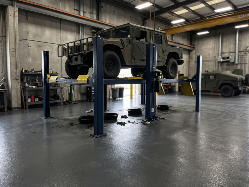 Motor pool bay with a dark gray coved epoxy floor and lift