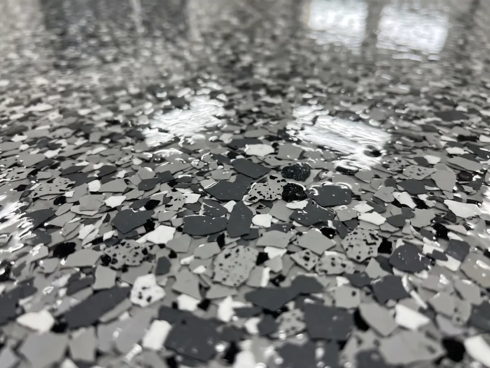 Close-up of gray and charcoal flakes sealed under a glass-smooth polyaspartic topcoat
