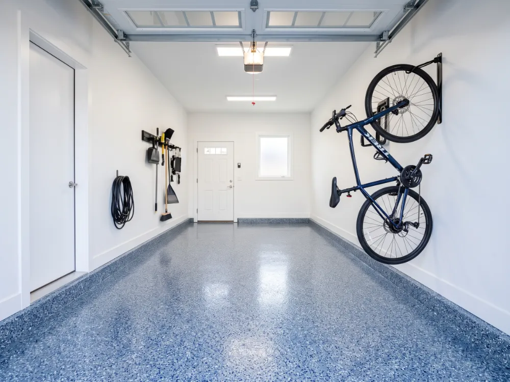 Single-car garage with a blue-gray and white flake floor built on a polyurea base