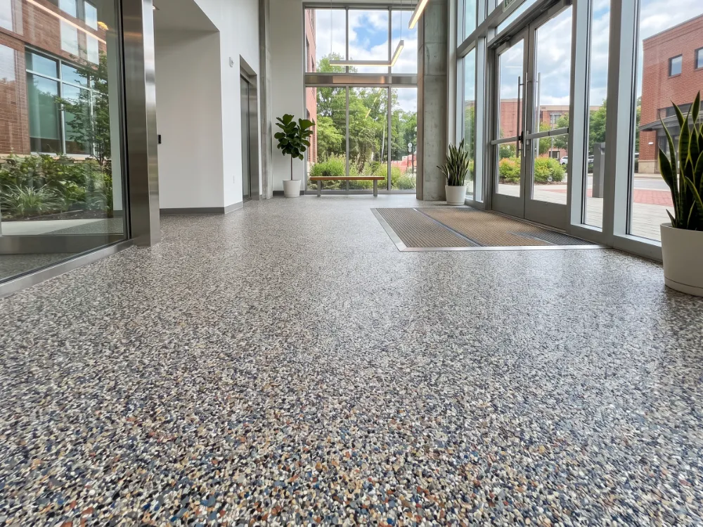 Dense multicolor quartz and flake broadcast floor in a bright commercial entryway