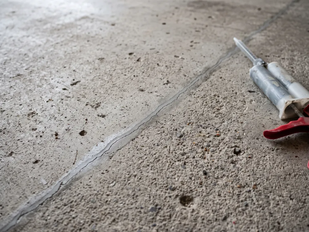 Structural crack filled with epoxy compound and ground flush in a garage floor