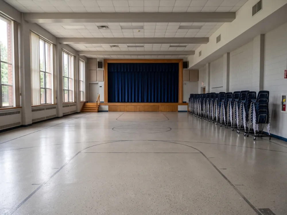 School multipurpose room with a neutral flake epoxy floor and stage