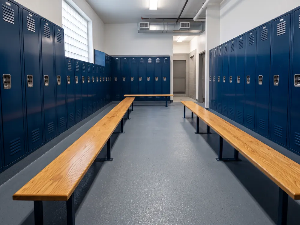 Locker room with a textured slate-gray epoxy floor and cove base