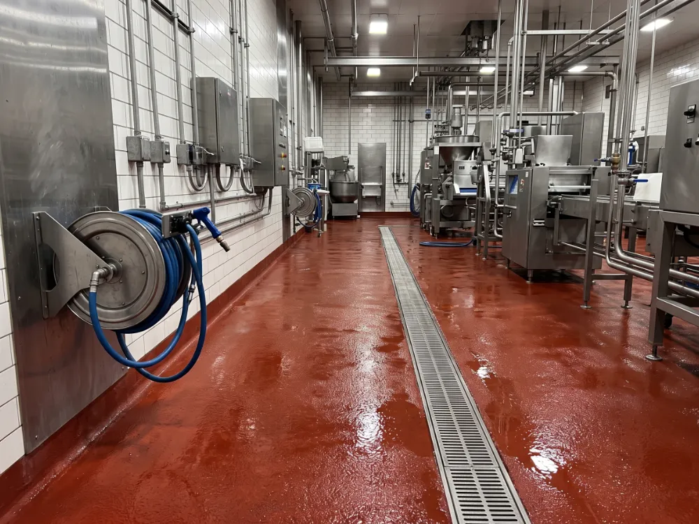 Wash-down area with a red urethane cement floor sloping to a trench drain