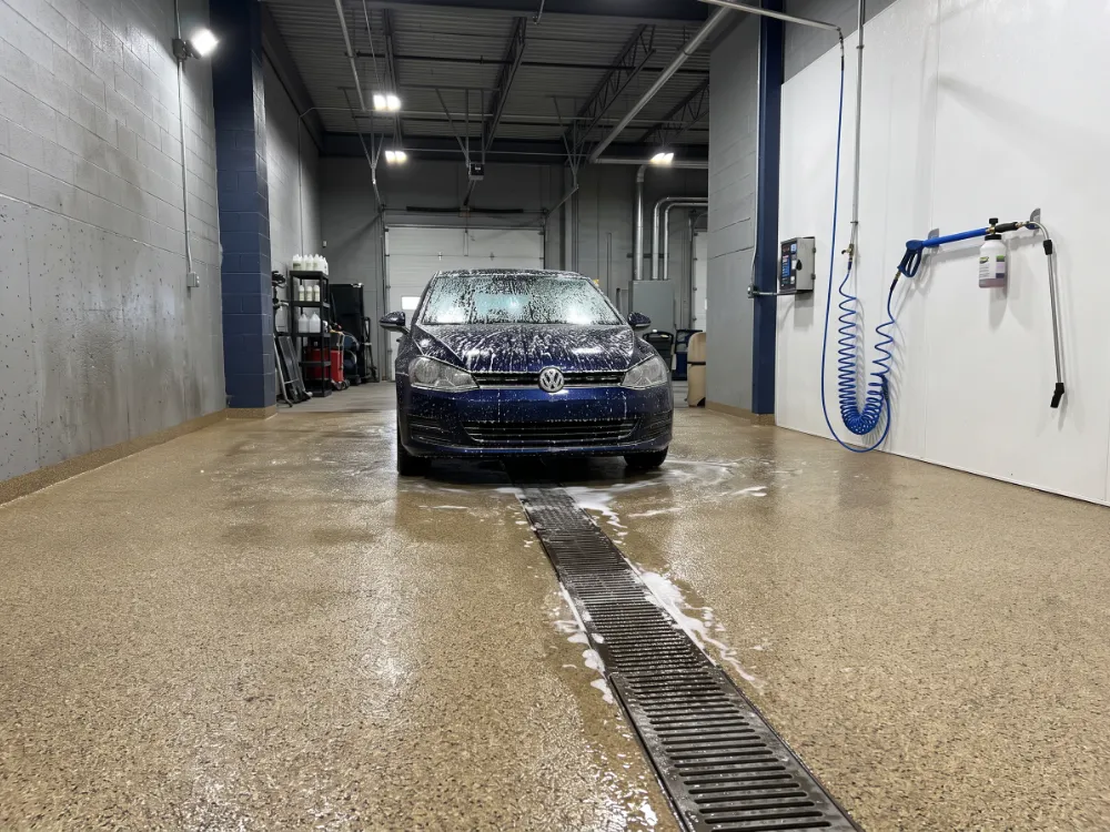 Wash bay with a textured quartz epoxy floor sloping to a drain